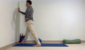 Jeff Bailey demonstrating a gentle wall-supported Avita Yoga shape to improve balance, joint health, and neuromuscular connection.